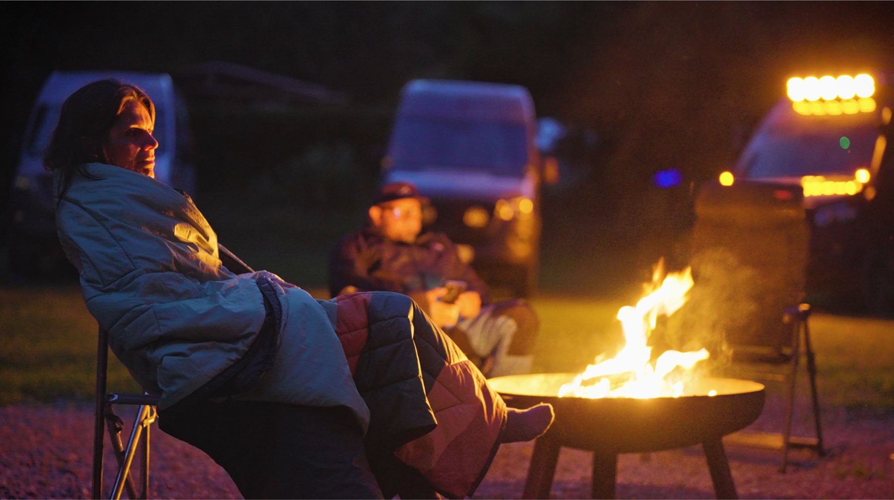 Die Reisegruppe sitzt abends neben den Campern am Lagerfeuer